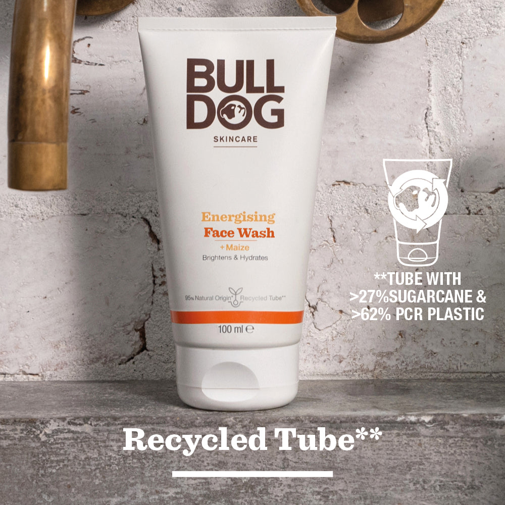 A tube of Energising Face Wash stands on wood, made with over 27% sugarcane, 62% recycled plastic, and natural origin ingredients to revitalise tired skin. Recycled Tube** appears at the bottom.