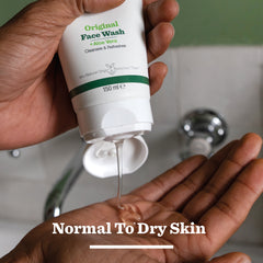 A person squeezes clear gel from a tube of Original Face Wash onto their palm. This face wash for men is made with aloe vera and natural origin ingredients, suitable for normal to dry skin. The scene takes place by a bathroom sink.