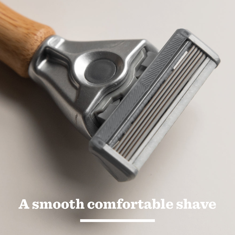 Close-up of the Original Bamboo Razor with tempered steel blades on a light surface, featuring the text A smooth comfortable shave below the razor.