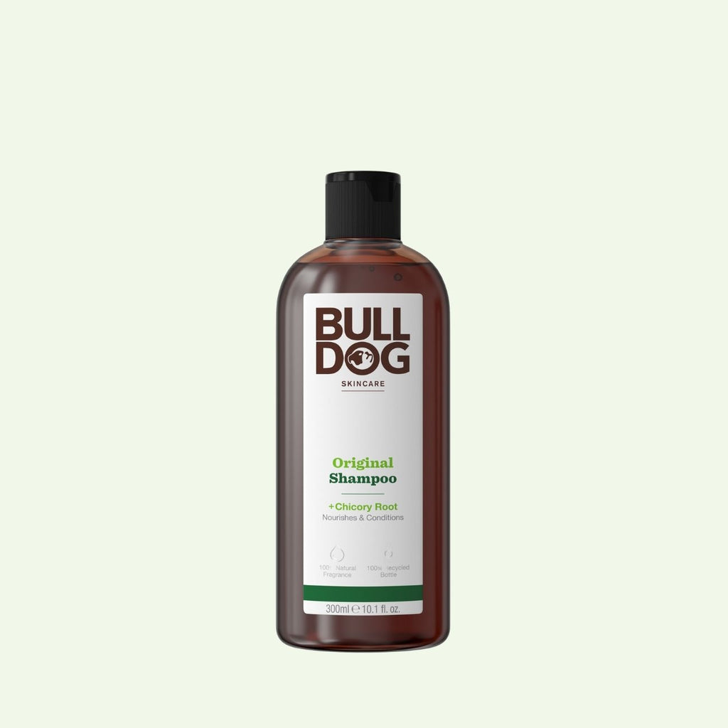 A 300ml (10.1 fl oz) brown bottle of Bulldog Skincare Original Shampoo, for men’s hair care, features a black cap, white label with green accents, and contains natural ingredients like chicory root to nourish and condition.
